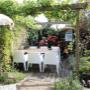 mozaiek-stadstuinontwerp-nijmegen-buiten-eettafel-onder-pergola-parasolletje-op- voorgrond