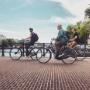 Cyclists on a tour going over skinny bridge in Amsterdam