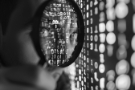 man-looking-through-magnifying-glass-inspecting-encryption.jpg