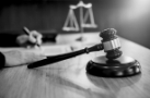 cropped-image-judge-writing-with-gavel-table.jpg