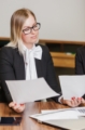 blonde-woman-sitting-desk-holding-sheets